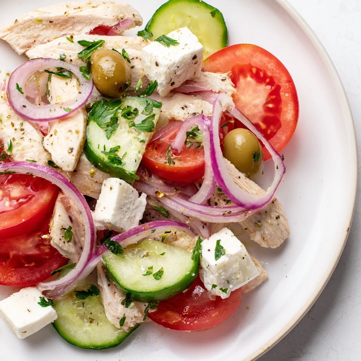 A colorful close-up of Greek salad with grilled chicken ready for a healthy dinner.