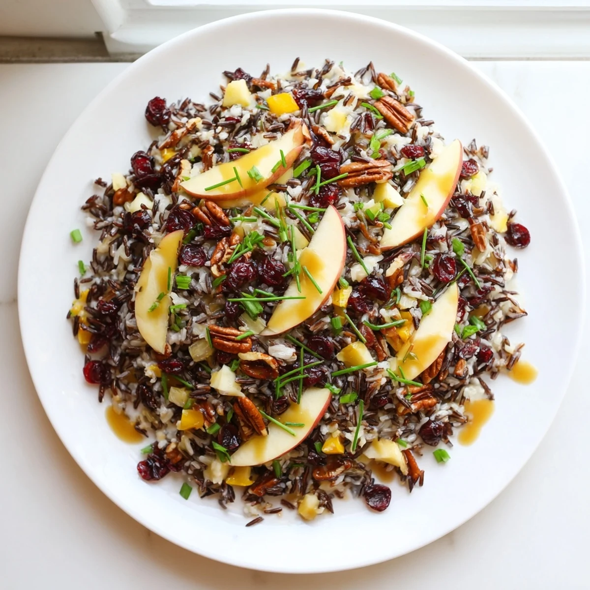A vibrant Wild Rice Harvest Salad with toasted pecans, dried cranberries, and fresh herbs in a zesty vinaigrette.