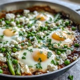 Colorful vegetarian Pea and Broad Bean Shakshuka topped with crumbled feta and herbs, served warm in a skillet for sharing.