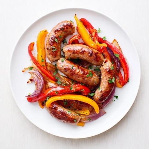 Golden-brown Italian sausage, peppers, and onions roasted on a sheet pan, ready for a flavorful dinner.