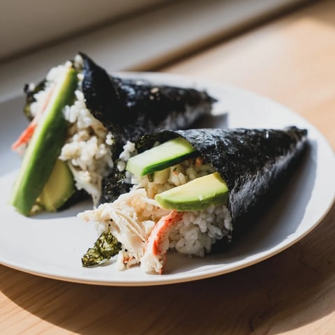 Hand-held sushi rice hand rolls with creamy avocado, crisp cucumber, and crab wrapped in fresh nori sheets, served with classic dipping sauces.