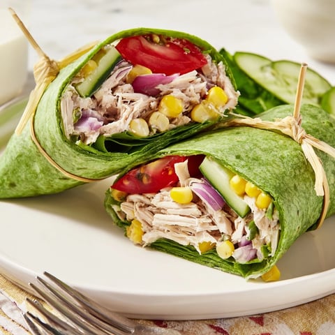 Savory BBQ Chicken Salad Wrap halves showing juicy BBQ chicken, crisp veggies, and creamy dressing in a spinach tortilla.
