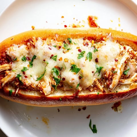 Golden garlic bread boats filled with savory chicken marinara and topped with bubbling mozzarella for a hearty Italian-American meal.