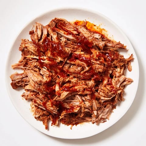 A close-up of slow-cooked 5-Ingredient BBQ Pulled Pork, delicious and ready to be served on a bun.