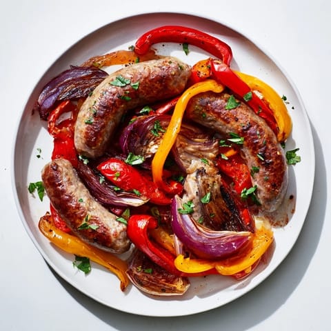 Vibrant sheet pan Italian sausage with roasted peppers and onions, garnished with fresh parsley, looks delicious.