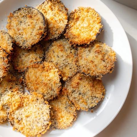Freshly baked Eggplant Parmesan Chips, lightly browned and sprinkled with herbs, perfect snack or appetizer.
