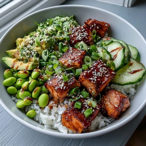 Freshly baked marinated salmon cubes, fluffy jasmine rice, edamame, cucumber, and avocado are all drizzled with a creamy, spicy sriracha mayo in this vibrant Salmon Rice Bowl.
