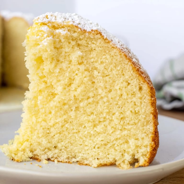 A close-up of a freshly baked Simple 3-Ingredient Vanilla Sponge Cake, light and airy, ready to frost.