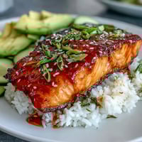 Pan-fried Honey Sriracha Salmon Bowl with glazed salmon, fluffy jasmine rice, and creamy avocado slices.