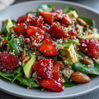 Fresh strawberry avocado quinoa salad with creamy avocado and juicy berries, tossed in zesty citrus dressing for a vibrant, healthy meal.