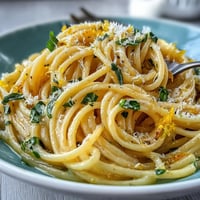 Bright Spring Pasta Limone garnished with fresh basil and grated parmesan.